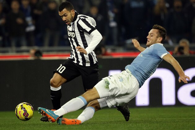 Lazio's Stefan De Vrij, right, and Juventus' Carlos Tevez  vie for the ball during their Serie A soccer match between Lazio and Juventus at Rome's Olympic Stadium, Saturday, Nov. 22, 2014. (AP Photo/Gregorio Borgia)