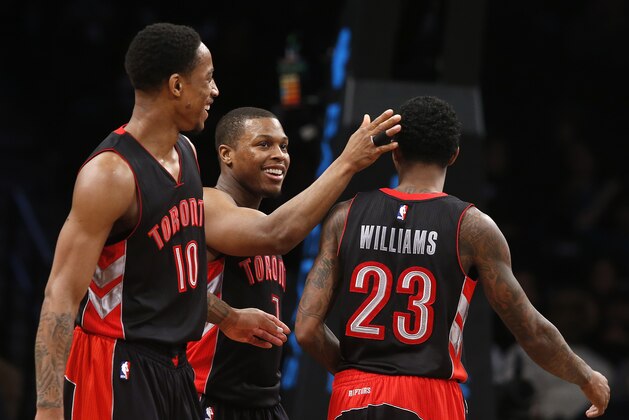 Toronto Raptors' Lou Williams (23) is congratulated by teammates Kyle Lowry (7) and DeMar DeRozan (10) after scoring against the Brooklyn Nets during the third quarter of an NBA basketball game Friday, Jan. 30, 2015, in New York.  Toronto defeated Brooklyn 127-122 in overtime. (AP Photo/Jason DeCrow)