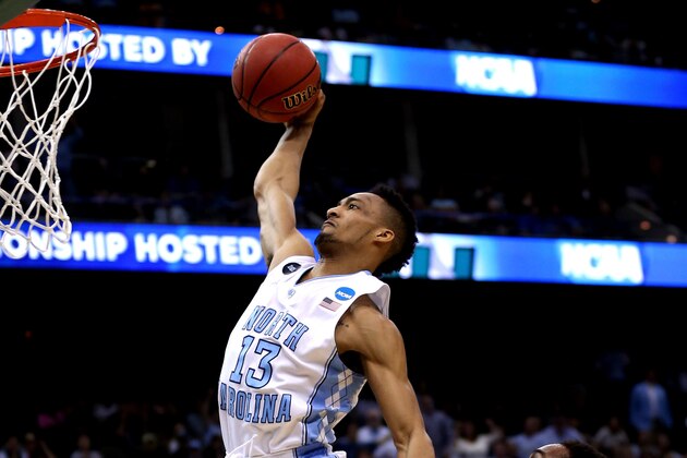 JACKSONVILLE, FL - MARCH 21: J.P. Tokoto #13 of the North Carolina Tar Heels dunks past Rashad Madden #00 of the Arkansas Razorbacks in the first half during the third round of the 2015 NCAA Men's Basketball Tournament at Jacksonville Veterans Memorial Arena on March 21, 2015 in Jacksonville, Florida.  (Photo by Mike Ehrmann/Getty Images)