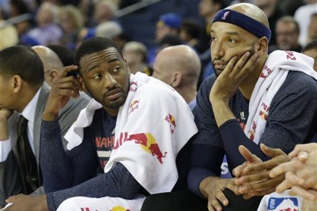 Washington Wizards guard John Wall, left, and forward Drew Gooden sit on the bench during the second half of an NBA basketball game against the Golden State Warriors in Oakland, Calif., Monday, March 23, 2015. The Warriors won 107-76. (AP Photo/Jeff Chiu)