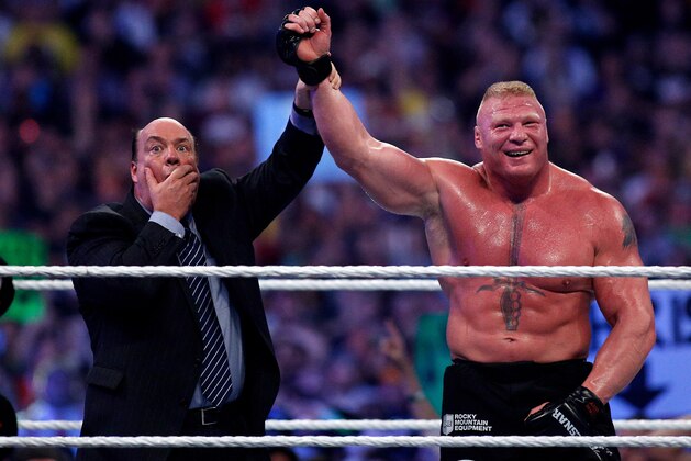 Paul Heyman, left, celebrates with Brock Lesnar after his win over the Undertaker  during Wrestlemania XXX at the Mercedes-Benz Super Dome in New Orleans on Sunday, April 6, 2014. (Jonathan Bachman/AP Images for WWE)
