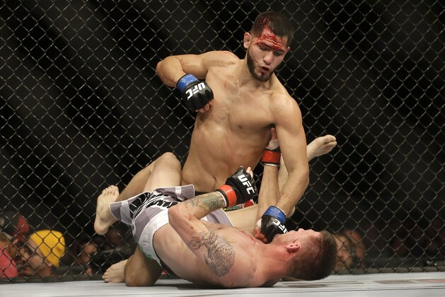 Jorge Masvidal, top, punches Tim Means during a UFC lightweight mixed martial arts fight in San Jose, Calif., Saturday, April 20, 2013. Masvidal won by unanimous decision. (AP Photo/Jeff Chiu)