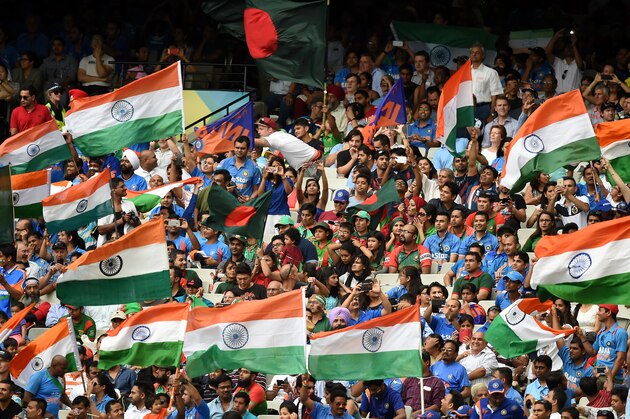 Indian fans wave their flags as they cheer their team during their Cricket World Cup quarterfinal match against Bangladesh in Melbourne, Australia, Thursday, March 19, 2015. (AP Photo/Andy Brownbill)