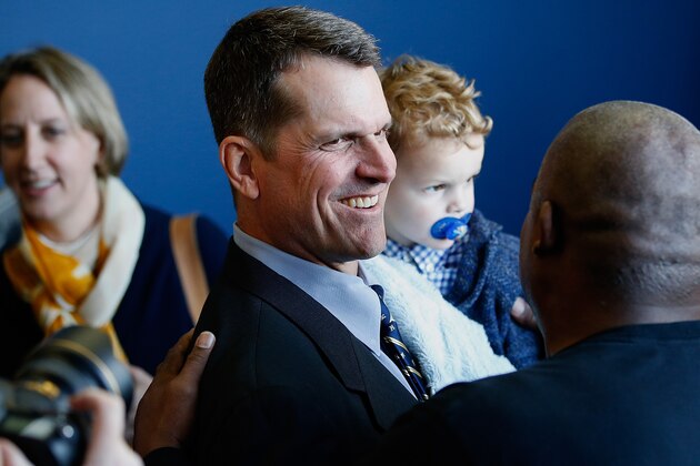 ANN ARBOR, MI - DECEMBER 30:  Jim Harbaugh carries his son Jack while leaving the press conference where he was introduced as the new Head Coach of the University of Michigan football team at the Junge Family Champions Center on December 30, 2014 in Ann Arbor, Michigan.  (Photo by Gregory Shamus/Getty Images)