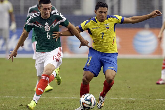 Mexico's Hector Herrera, left, pressures Ecuador forward Jefferson Montero (7) during the first half of a friendly soccer match, Saturday, May 31, 2014, in Arlington, Texas.  (AP Photo/Tony Gutierrez)