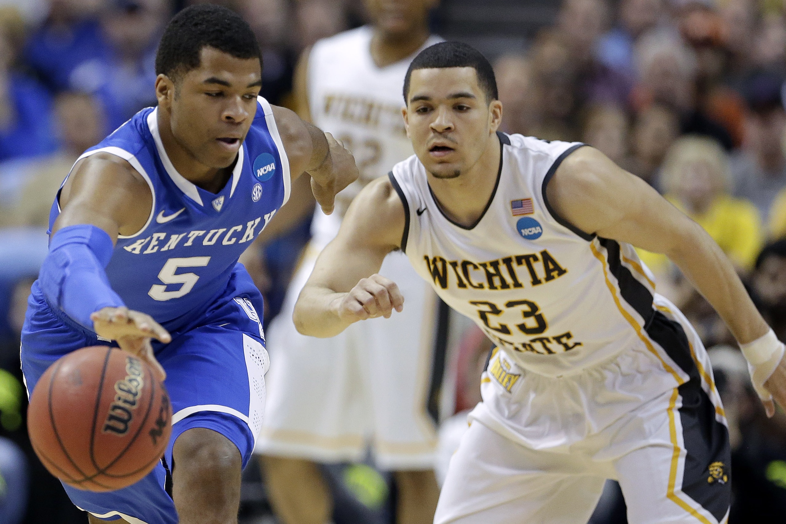Kentucky guard Andrew Harrison (5) and Wichita State guard Fred VanVleet (23) go for a loose ball during the first half of a third-round game of the NCAA college basketball tournament Sunday, March 23, 2014, in St. Louis. (AP Photo/Charlie Riedel)