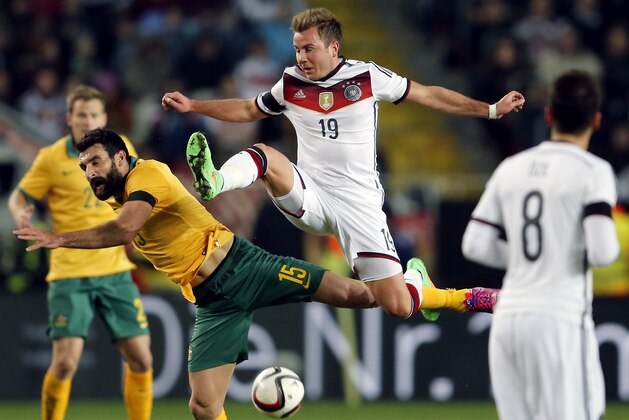 Austarlia's Mile Jedinak, left, and Germany's Mario Goetze, right, challenge for the ball during a soccer friendly match between Germany and Australia in Kaiserslautern, Germany, Wednesday, March 25, 2015. (AP Photo/Michael Probst)