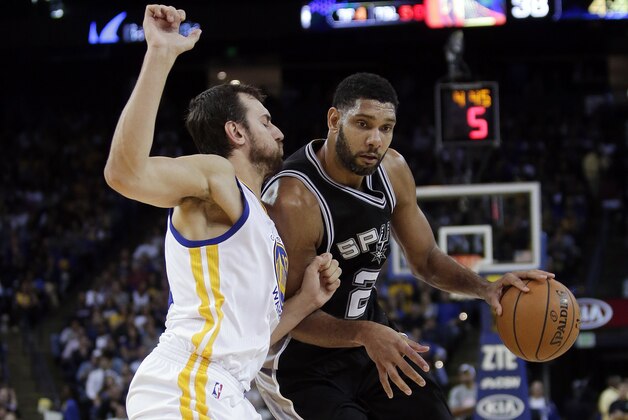 San Antonio Spurs' Tim Duncan, right, drives  Golden State Warriors' Andrew Bogut during the first half of an NBA basketball game Tuesday, Nov. 11, 2014, in Oakland, Calif. (AP Photo/Marcio Jose Sanchez)