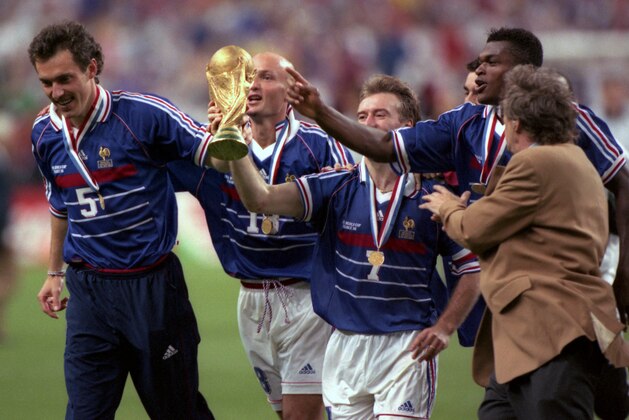 Some of the France soccer team celebrate on the pitch with the world cup after they defeated Brazil in the World Cup Final, in Stade de France, in Saint-Denis, Paris, July 12, 1998. France defeated Brazil 3-0. (AP Photo/ Eric Draper)