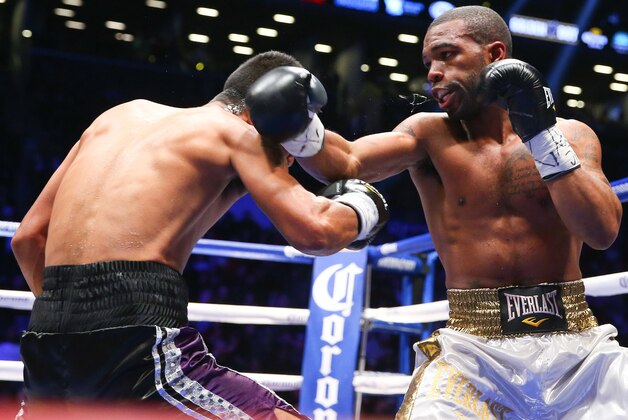 Jan 30, 2014; Brooklyn, NY, USA; Gary Russell Jr (White/Gold trunks) and Miguel Tamayo (Black/Purple trunks) trade punches during their bout at Barclays Center. Mandatory Credit: Ed Mulholland-USA TODAY Sports