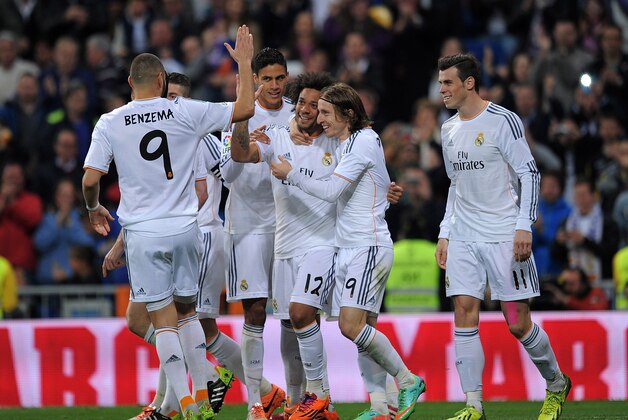 MADRID, SPAIN - MARCH 09:  Marcelo (#12) of Real Madrid CF celebrates Karim Benzema (L), Gareth Bale (R) and Luka Modric (2nd R) after he scored Real's 2nd goal during the La Liga match between Real Madrid CF and Levante UD at Santiago Bernabeu stadium on March 9, 2014 in Madrid, Spain.  (Photo by Denis Doyle/Getty Images)