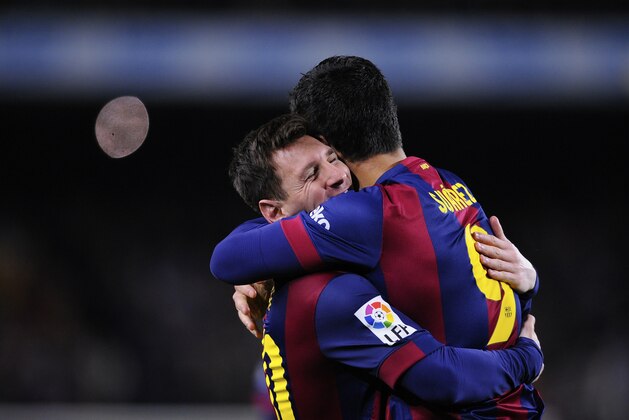 Barcelona's Lionel Messi, left, hugs Luis Suarez after Suarez scored his team's second goal during a Spanish La Liga soccer match between FC Barcelona and Real Madrid at Camp Nou stadium, in Barcelona, Spain, Sunday, March 22, 2015. (AP Photo/Manu Fernandez)