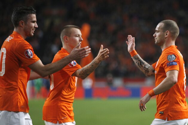 Netherlands' Robin van Persie, left, Jordy Clasie, center, and Wesley Sneijder celebrate after scoring during the Euro 2016 group A qualifying round soccer match between the Netherlands and Latvia at ArenA stadium in Amsterdam, Netherlands, Sunday, Nov. 16, 2014. (AP Photo/Peter Dejong)
