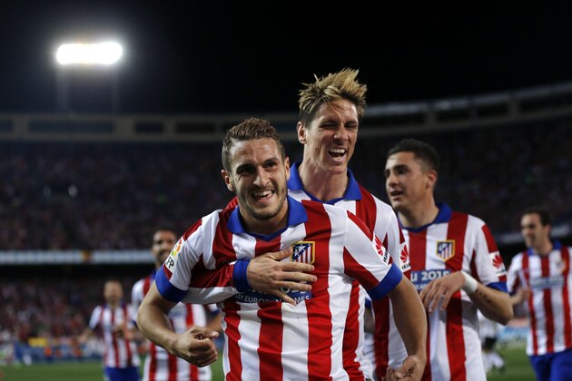 Atletico de Madrid’s Koke, left, is embraced by team mate Fernando Torres as he celebrates after scoring a goal during a Spanish La Liga soccer match between Atletico de Madrid and Valencia at the Vicente Calderon stadium in Madrid, Spain, Sunday, March 8, 2015. (AP Photo/Daniel Ochoa de Olza)