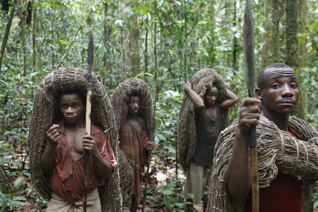 In this March 18, 2010 photo, Mbuti pygmy men, from left, Faizi Malambi, Kawaya Situka, Besei, and Kange Ambali carry their hunting nets and spears as they await the start of the day's hunt, in the Okapi Wildlife Reserve outside the town of Epulu, Congo. The pygmies traditional practice of hunting bushmeat has devolved into an all-out commercial endeavor, staged not for subsistence, but to feed growing regional markets. The result: the forests, those that remain, are growing emptier by the day. (AP Photo/Rebecca Blackwell)