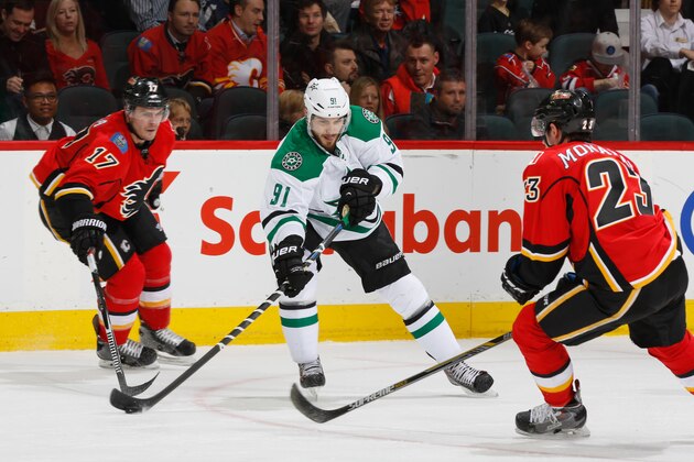 CALGARY, AB - MARCH 25: Tyler Seguin #91 of the Dallas Stars protects the puck against Lance Bouma #17 and Sean Monahan #23 of the Calgary Flames at Scotiabank Saddledome on March 25, 2015 in Calgary, Alberta, Canada. (Photo by Gerry Thomas/NHLI via Getty Images)