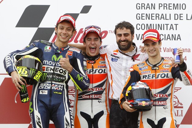 2nd placed Moto GP rider Valentino Rossi of Italy, left, Moto GP World Champion and race winner Marc Marquez of Spain, 2nd left and  3rd placed Dani Pedrosa of Spain, right pose with the Repsol team chief mechanic Santi Hernendez during the Valencia Motorcycle Grand Prix, the last race of the season, at the Ricardo Tormo circuit in Cheste near Valencia, Spain, Sunday Nov. 9, 2014. (AP Photo/Alberto Saiz)