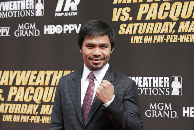 Boxer Manny Pacquiao, of the Philippines, pauses for photos as he arrives for a news conference, Wednesday, March 11, 2015, in Los Angeles. Pacquiao is scheduled to fight Floyd Mayweather Jr. in Las Vegas on May 2. (AP Photo/Jae C. Hong)