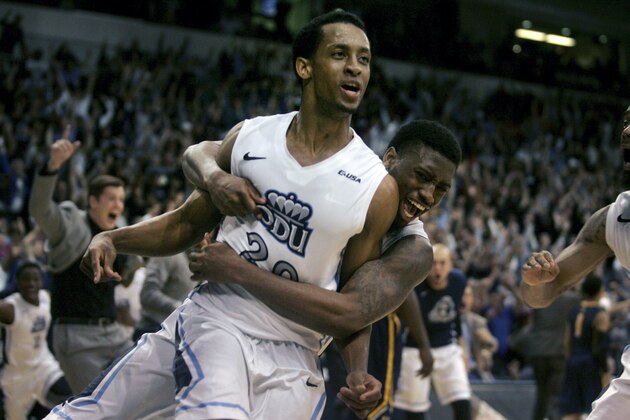 Old Dominion's Trey Freeman (20) is mobbed by teammates after hitting the game-winning shot at the buzzer to beat Murray State 72-69 in an NCAA college basketball game in the National Invitation Tournament, Wednesday, March 25, 2015 in Norfolk, Va. (AP Photo/Jason Hirschfeld)