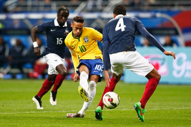 PARIS, FRANCE - MARCH 26:  Neymar of Brazil shoots on goal in front of Raphael Varane and Bacary Sagna of France during the International Friendly match between France and Brazil at the Stade de France on March 26, 2015 in Paris, France.  (Photo by Dean Mouhtaropoulos/Getty Images)