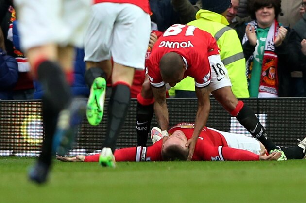 MANCHESTER, ENGLAND - MARCH 15:  Wayne Rooney (ground) of Manchester United is congratulated by teammates after scoring his team's third goal during the Barclays Premier League match between Manchester United and Tottenham Hotspur at Old Trafford on March 15, 2015 in Manchester, England.  (Photo by Alex Livesey/Getty Images)