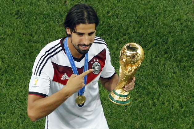 Germany's Sami Khedira points at the trophy after winning the World Cup final soccer match between Germany and Argentina at the Maracana Stadium in Rio de Janeiro, Brazil, Sunday, July 13, 2014. Mario Goetze volleyed in the winning goal in extra time to give Germany its fourth World Cup title with a 1-0 victory over Argentina on Sunday. (AP Photo/Fabrizio Bensch, Pool)