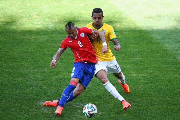 BELO HORIZONTE, BRAZIL - JUNE 28:  Arturo Vidal of Chile and Luiz Gustavo of Brazil compete for the ball during the 2014 FIFA World Cup Brazil round of 16 match between Brazil and Chile at Estadio Mineirao on June 28, 2014 in Belo Horizonte, Brazil.  (Photo by Ian Walton/Getty Images)