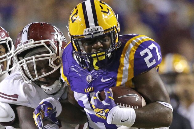 LSU running back Kenny Hilliard (27) is tackled by New Mexico State defensive end Jay Eakins as defensive back Kawe Johnson, rear, closes in during the second half of an NCAA college football game in Baton Rouge, La., Saturday, Sept. 27, 2014. LSU won 63-7. (AP Photo/Gerald Herbert)