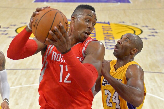 Houston Rockets center Dwight Howard, left, grabs a rebound away from Los Angeles Lakers guard Kobe Bryant during the second half of an NBA basketball game, Tuesday, Oct. 28, 2014, in Los Angeles.  The Rockets won 108-90. (AP Photo/Mark J. Terrill)