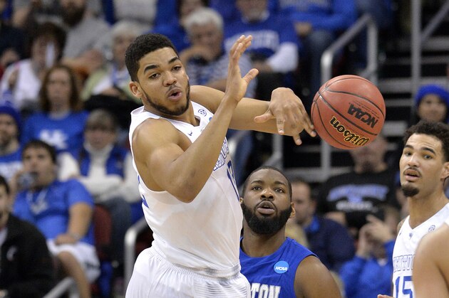 Kentucky's Karl-Anthony Towns, left, passes the ball to Kentucky's Devin Booker during the first half of an NCAA tournament second round college basketball game against Hampton in Louisville, Ky., Thursday, March 19, 2015. (AP Photo/Timothy D. Easley)