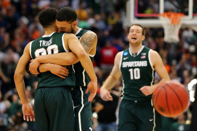 SYRACUSE, NY - MARCH 27:  Denzel Valentine #45 of the Michigan State Spartans celebrates with teammate Travis Trice #20 after defeating the Oklahoma Sooners 62 to 58 during the East Regional Semifinal of the 2015 NCAA Men's Basketball Tournament at the Carrier Dome on March 27, 2015 in Syracuse, New York.  (Photo by Elsa/Getty Images)