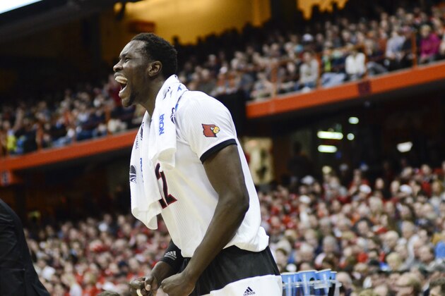 Louisville's Mangok Mathiang cheers for his teammates during the first half of a regional semifinal against North Carolina State in the NCAA men's college basketball tournament Friday, March 27, 2015, in Syracuse, N.Y.  (AP Photo/Heather Ainsworth)