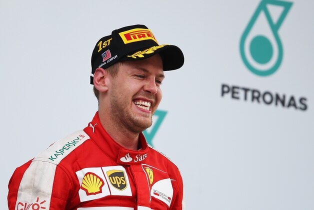 KUALA LUMPUR, MALAYSIA - MARCH 29: Sebastian Vettel of Germany and Ferrari smiles as he celebrates victory on the podium after the Malaysia Formula One Grand Prix at Sepang Circuit on March 29, 2015 in Kuala Lumpur, Malaysia.  (Photo by Clive Mason/Getty Images)
