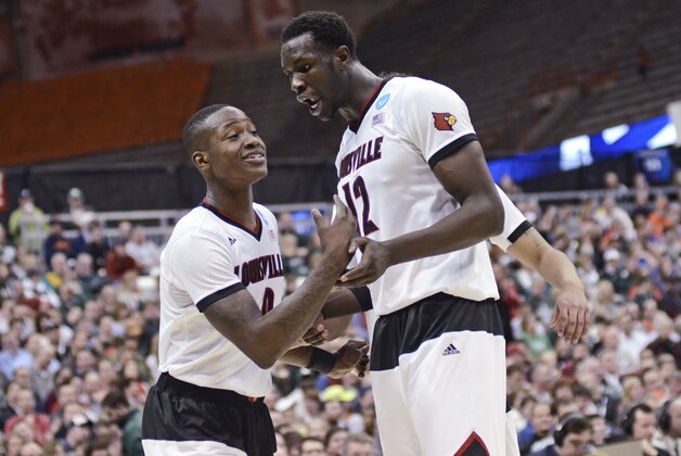 Louisville's Terry Rozier (0) reacts with teammate Mangok Mathiang (12) during the first half of a regional semifinal against North Carolina State in the NCAA men's college basketball tournament Friday, March 27, 2015, in Syracuse, N.Y.  (AP Photo/Heather Ainsworth)