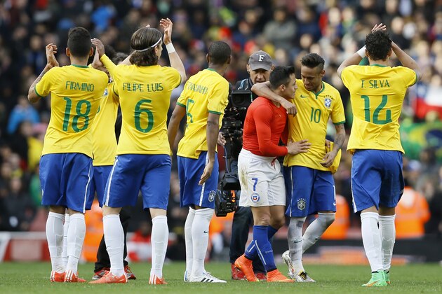 Chile’s Alexis Sanchez, in red, is hugged by Brazil’s Neymar following the end of  the international friendly soccer match soccer match between Brazil and Chile at the Emirates stadium in London, Sunday, March 29, 2015.  Brazil won the match 1-0.  (AP Photo/Kirsty Wigglesworth)