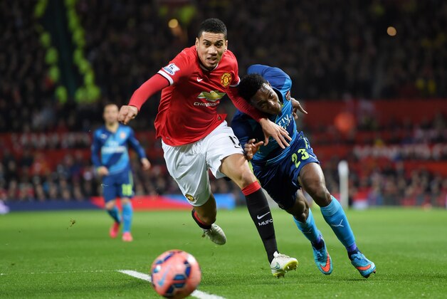 MANCHESTER, ENGLAND - MARCH 09:  Chris Smalling of Manchester United and Danny Welbeck of Arsenal battle for the ball during the FA Cup Quarter Final match between Manchester United and Arsenal at Old Trafford on March 9, 2015 in Manchester, England.  (Photo by Michael Regan/Getty Images)