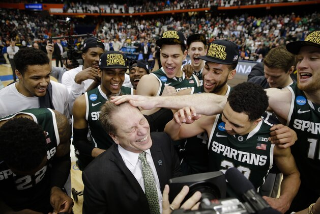 Michigan State head coach Tom Izzo, center front, celebrates with his team after the regional final against Louisville in the NCAA men's college basketball tournament Sunday, March 29, 2015, in Syracuse, N.Y. Michigan State won the game 76-70. (AP Photo/Seth Wenig)