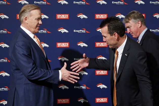 Denver Broncos general manager and executive vice president of football operations shakes hands with new head coach Gary Kubiak as Joe Ellis, President, Chairman and CEO of the Denver Broncos, looks on following a news conference Tuesday, Jan. 20, 2015, in Englewood, Colo., (AP Photo/Jack Dempsey)