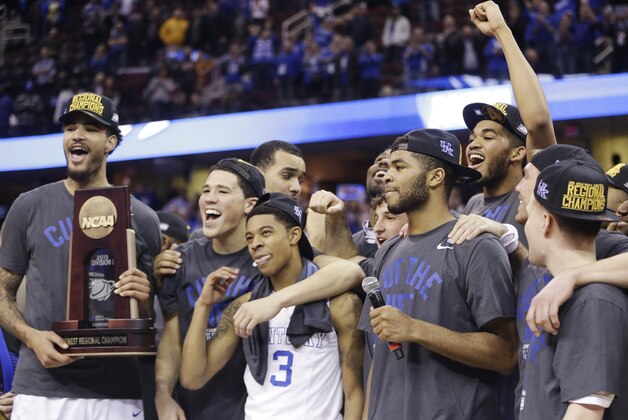 Kentucky players celebrate with the regional championship trophy after a 68-66 win over Notre Dame in a college basketball game in the NCAA men's tournament regional finals, Saturday, March 28, 2015, in Cleveland. (AP Photo/Tony Dejak)