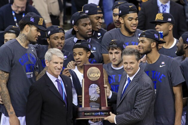Kentucky coach John Calipari, right, holds the regional championship trophy after the team's 68-66 win over Notre Dame in a college basketball game in the NCAA men's tournament regional finals, Saturday, March 28, 2015, in Cleveland. Kentucky advanced to the Final Four at 38-0. (AP Photo/Aaron Josefczyk)