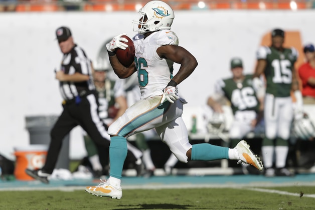 Miami Dolphins running back Lamar Miller (26) runs a 97 yard touchdown during the second half of an NFL football game against the New York Jets, Sunday, Dec. 28, 2014, in Miami Gardens, Fla. (AP Photo/Wilfredo Lee)