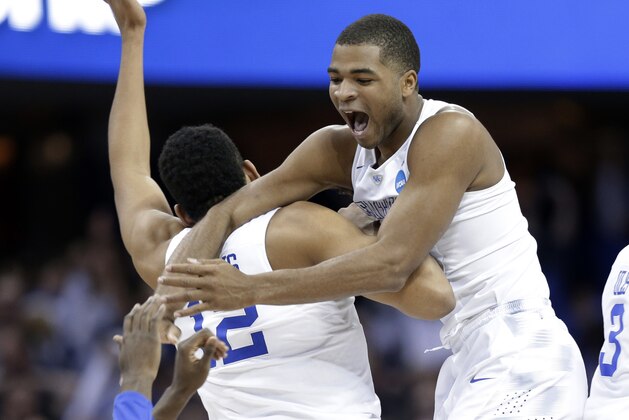Kentucky's Aaron Harrison, right, leaps on Karl-Anthony Towns (12) after the team's 68-66 win over Notre Dame in a college basketball game in the NCAA men's tournament regional finals, Saturday, March 28, 2015, in Cleveland. Kentucky advances to the Final Four with a 38-0 record. (AP Photo/Tony Dejak)