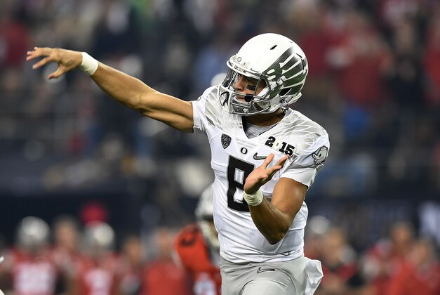 Jan 12, 2015; Arlington, TX, USA; Oregon Ducks quarterback Marcus Mariota (8) throws during the first quarter in the 2015 CFP National Championship Game at AT&T Stadium. Ohio State Buckeyes defeated Oregon Ducks 42-20. Mandatory Credit: Tommy Gilligan-USA TODAY Sports