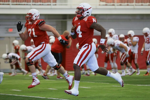 Nebraska quarterback Tommy Armstrong Jr. (4) and Nebraska offensive lineman Alex Lewis (71) run during spring practice in Lincoln, Neb., Wednesday, March 11, 2015. (AP Photo/Nati Harnik)