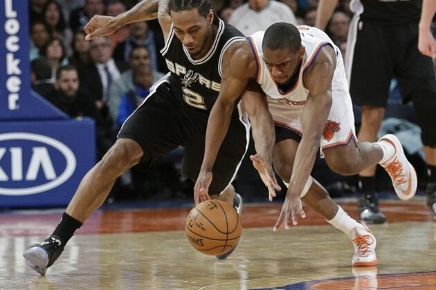 San Antonio Spurs' Kawhi Leonard (2) and New York Knicks' Langston Galloway (2) fight for control of the ball during the second half of an NBA basketball game Tuesday, March 17, 2015, in New York. The Knicks won the game 104-100. (AP Photo/Frank Franklin II)
