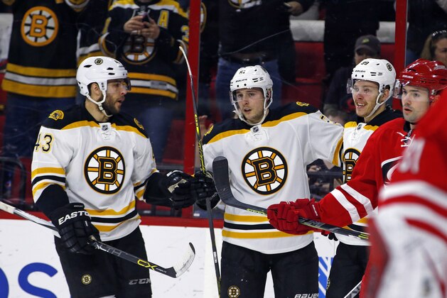 Boston Bruins' Ryan Spooner, second from left, celebrates his goal with teammates Matt Bartkowski (43) and David Pastrnak (88) during the first period of an NHL hockey game against the Carolina Hurricanes, Sunday, March 29, 2015, in Raleigh, N.C. Boston won 2-1 in overtime. (AP Photo/Karl B DeBlaker)
