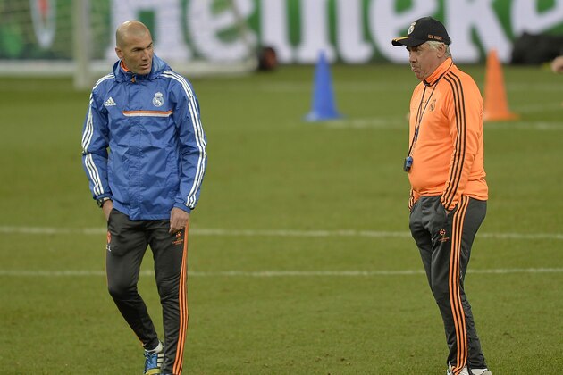 Real's head coach Carlo Ancelotti, right, talks to assistant coach Zinedine Zidane during the last training session prior the UEFA Champions League first leg knock out soccer match between FC Schalke 04 and Real Madrid in Gelsenkirchen, Tuesday, Feb. 25, 2014.  (AP Photo/Martin Meissner)