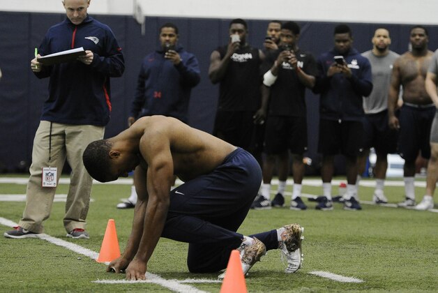 Byron Jones lines up to run as his teammates use cell phones to record him during  Connecticut's NFL football pro day, Tuesday, March 31, 2015, in Storrs, Conn. (AP Photo/Jessica Hill)
