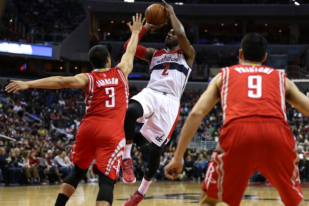 WASHINGTON, DC - MARCH 29: John Wall #2 of the Washington Wizards shoots over Nick Johnson #3 of the Houston Rockets in the second half at Verizon Center on March 29, 2015 in Washington, DC. NOTE TO USER: User expressly acknowledges and agrees that, by downloading and or using this photograph, User is consenting to the terms and conditions of the Getty Images License Agreement. (Photo by Patrick Smith/Getty Images)