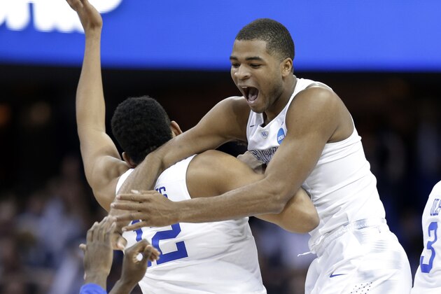 Kentucky's Aaron Harrison, right, leaps on Karl-Anthony Towns (12) after the team's 68-66 win over Notre Dame in a college basketball game in the NCAA men's tournament regional finals, Saturday, March 28, 2015, in Cleveland. Kentucky advances to the Final Four with a 38-0 record. (AP Photo/Tony Dejak)
